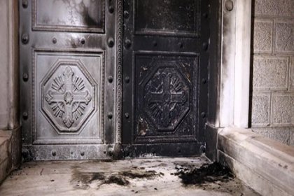 Kilisenin kapısını ateşe verdi
