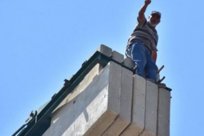 İzmir'de ücretlerini alamayan işçiler vince çıkarak eylem yaptı