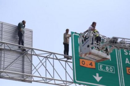 Paralarını alamayan işçiler trafik tabelasına çıktı